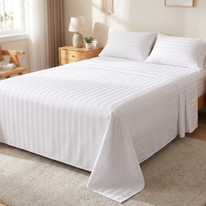 Drap plat en coton rayé blanc satiné installé sur un lit dans une chambre lumineuse
