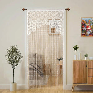 Rideau de porte en macramé blanc à franges suspendu à une tringle dans un intérieur lumineux