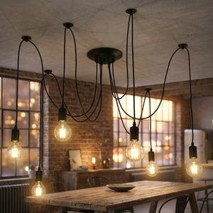 Lustre araignée vintage en métal noir avec plusieurs ampoules à filament suspendues au plafond d'un salon industriel