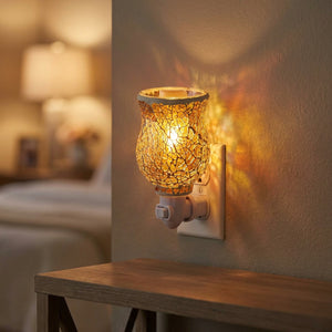 Diffuseur de parfum électrique en verre mosaïque allumé diffusant une lumière chaude et colorée sur une table de chevet