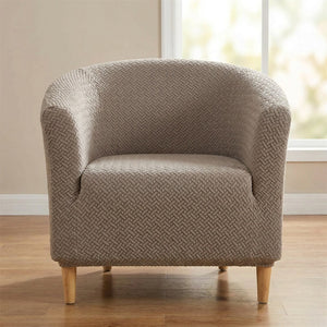 Housse de fauteuil club en jacquard texturé taupe installée sur un fauteuil cabriolet dans un salon lumineux