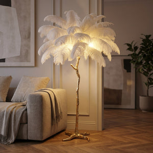 Lampadaire en plumes d'autruche blanches sur un pied branche doré diffusant une lumière chaude dans un salon