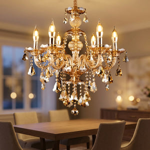 Lustre en cristal K9 doré aux pampilles ambrées suspendu dans une salle à manger chaleureuse