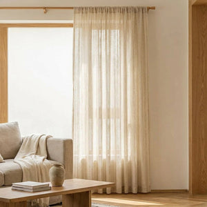 Rideau en gaze rayé beige dans un salon lumineux avec canapé et table basse en bois