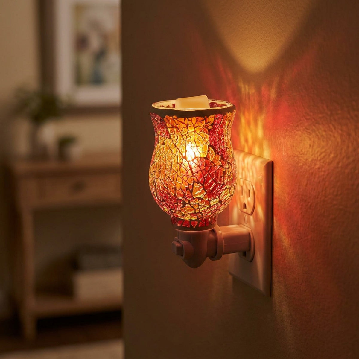Diffuseur de parfum électrique en verre mosaïque rouge allumé branché sur une prise dans un couloir