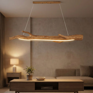 Lustre en résine noire imitant une branche allumé au dessus d'une table à manger en bois dans une salle chaleureuse