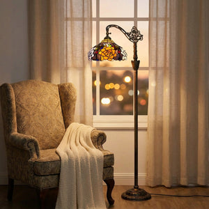 Lampadaire liseuse style Tiffany allumé dans un coin lecture près d'un fauteuil et d'une fenêtre