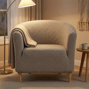 Housse de fauteuil club taupe sur un fauteuil dans un coin lecture avec lampadaire