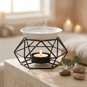 Brûle-parfum géométrique noir dans une salle de bain zen avec eucalyptus et galets