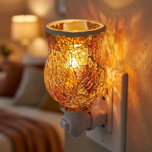 Gros plan sur un diffuseur de parfum en verre mosaïque ambré allumé branché au mur
