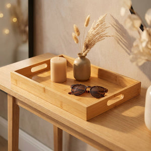 Plateau en bambou décoratif sur une console avec une bougie et un petit vase de pampa