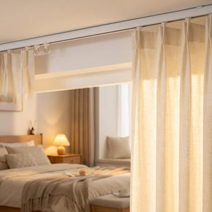 Rail de rideau blanc fixé au plafond d'une chambre avec voilage et lampe de chevet