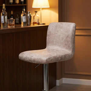 Housse de chaise de bar beige installée dans un coin bar chaleureux en soirée