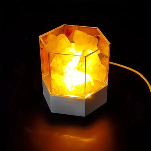 Lampe de sel hexagonale en cristal naturel allumée sur fond sombre