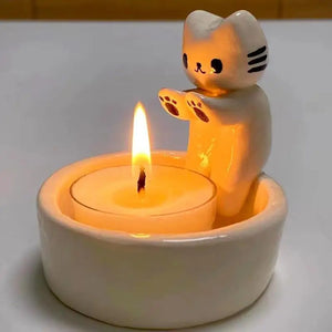 Gros plan du bougeoir chat en résine crème avec sa bougie allumée