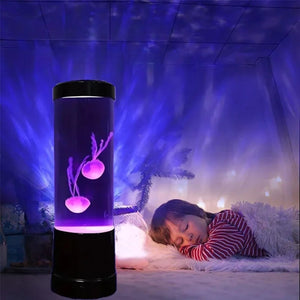 Lampe méduse allumée en violet dans une chambre avec enfant endormi en arrière-plan