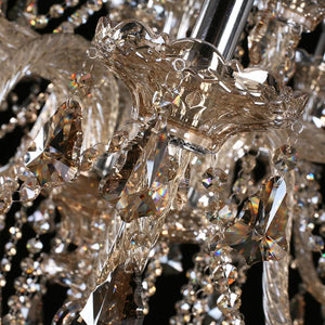 Gros plan sur les bras et les cristaux ambrés du lustre
