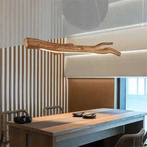 Lustre suspendu en résine forme branche au dessus d'une table à manger avec chaises