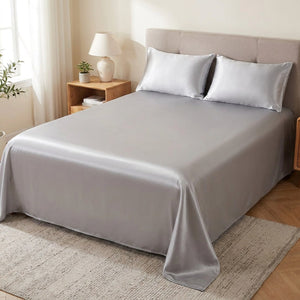 Drap housse en satin argenté sur un lit dans une chambre lumineuse