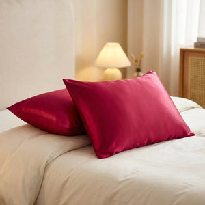 Deux taies d'oreiller en satin rouge sur un lit
