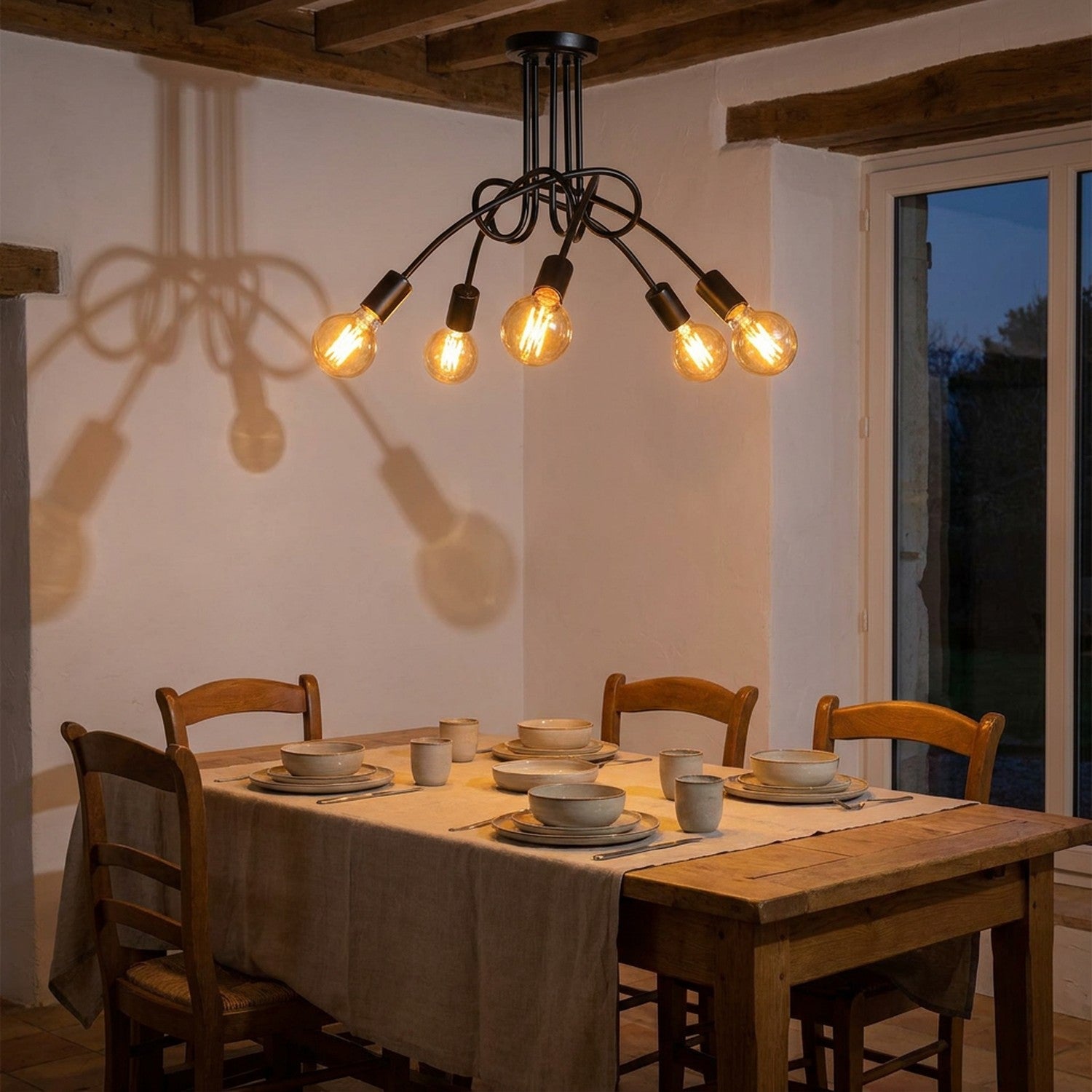 Lustre rétro noir 5 bras fer forgé au-dessus d'une table en salle à manger