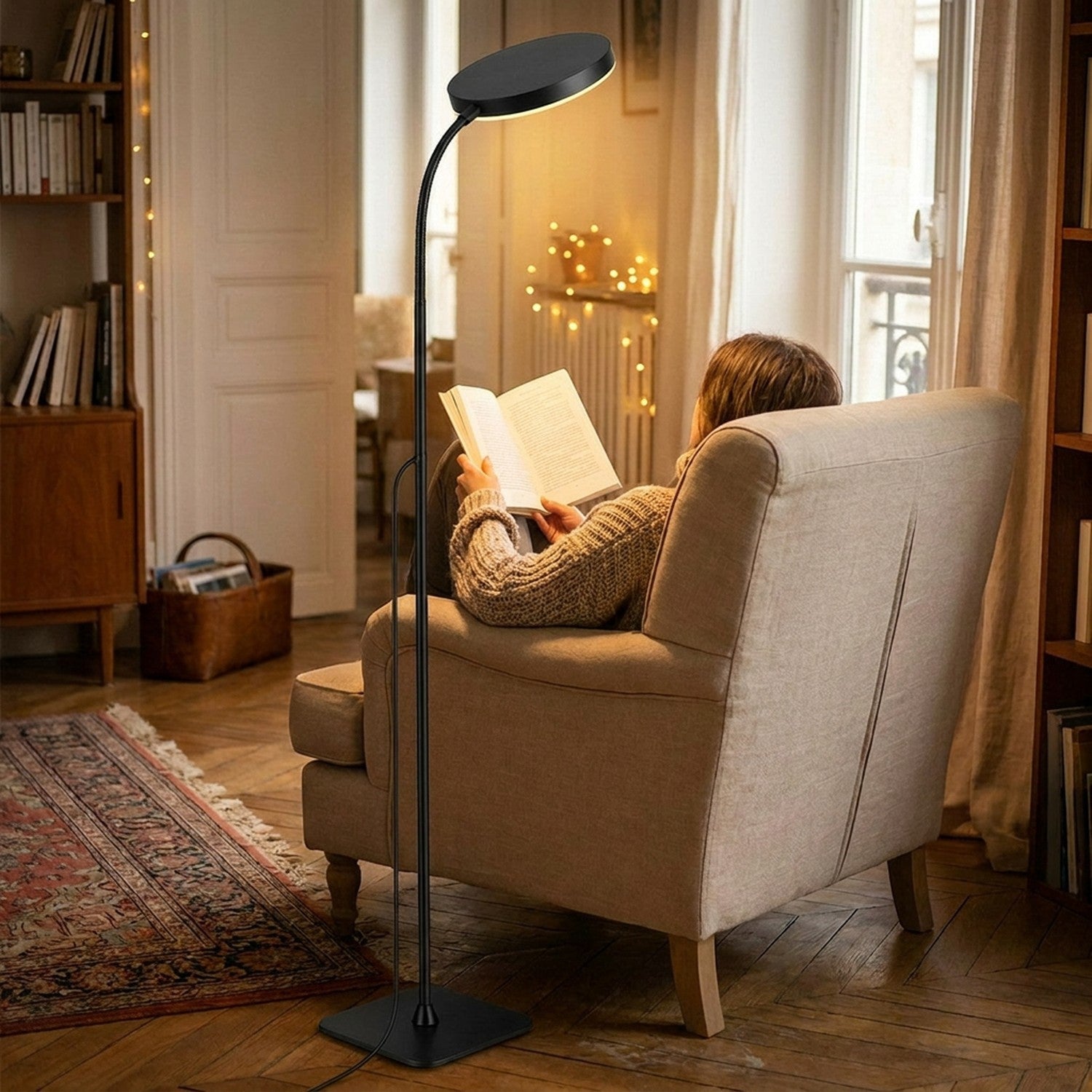 Personne lisant dans un fauteuil éclairée par un lampadaire liseuse LED col de cygne noir