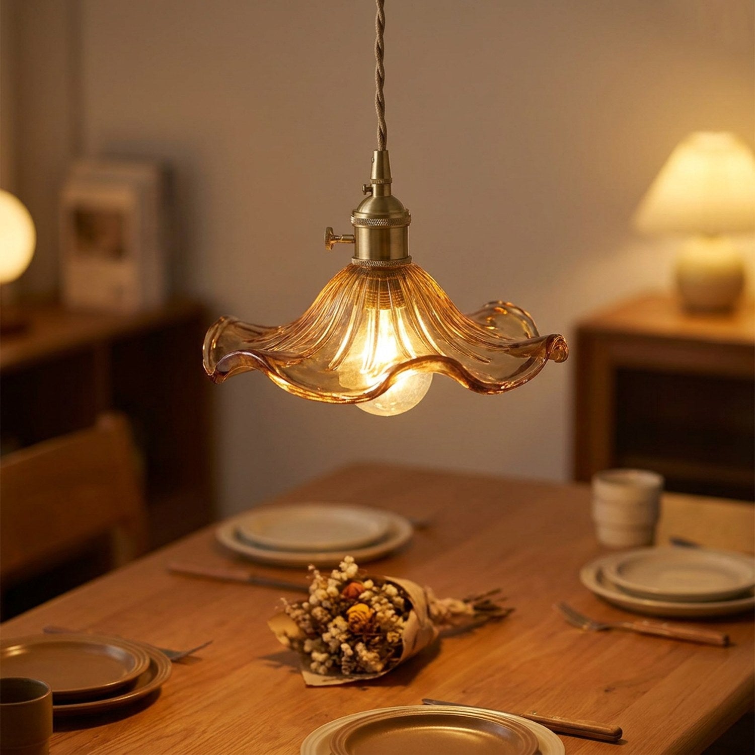Suspension fleur ambrée allumée au-dessus d'une table à manger dressée