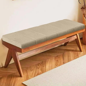 Coussin banc en velours doux et résistant aux taches, de couleur beige, posé sur un banc en bois aux pieds inclinés dans une entrée lumineuse avec parquet en bois clair.