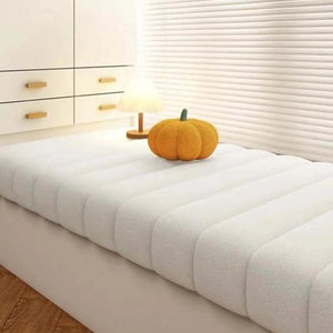 Coussin banquette imperméable avec surface matelassée et texture douce, posé sur une banquette intégrée dans une chambre lumineuse, offrant une assise épaisse et confortable.