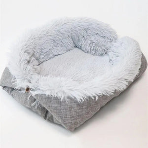 Un coussin chat pliable doux et moelleux avec une base rembourrée et un rebord en peluche formant un petit cocon, conçu pour permettre au chat de se blottir confortablement pendant ses siestes.