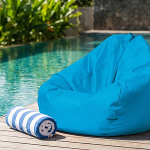 Pouf poire turquoise au bord d'une piscine ensoleillée