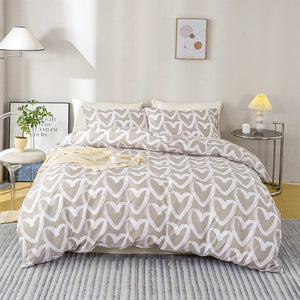 Une parure de lit beige clair avec motifs de cœurs blancs dessinés à la main, disposée dans une chambre lumineuse au style minimaliste et apaisant.