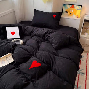 Parure de lit cœur brodé minimaliste avec petit cœur brodé sur la taie d’oreiller et la housse de couette, présentée dans une chambre cosy avec literie moelleuse et ambiance chaleureuse.