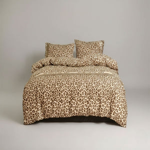 Une parure de lit léopard ambiance safari composée d’une housse de couette et de deux oreillers, disposée sur un lit avec un motif animalier audacieux créant une atmosphère sauvage et élégante.