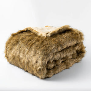 Un plaid canapé douillet en fausse fourrure, épais et moelleux, délicatement plié sur lui-même, offrant une texture dense et enveloppante idéale pour un moment cocooning.