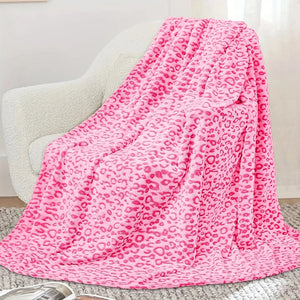 Un plaid léopard ultra moelleux et douillet délicatement posé sur un fauteuil, avec un rendu doux et enveloppant qui invite à la détente dans un intérieur cosy.
