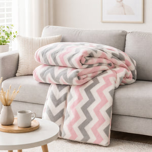 Un plaid polaire motif chevron aux lignes graphiques, créant une ambiance douce et confortable dans un salon lumineux.