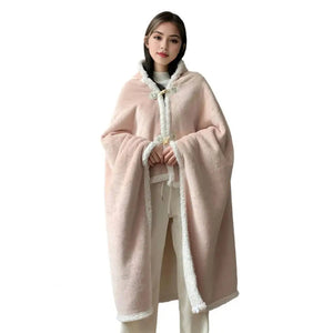 Un plaid poncho peluche double face avec capuche et bordures duveteuses, enveloppant le corps comme une cape douce et chaleureuse pour des moments cocooning à la maison.