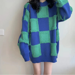 Un pull plaid femme oversize à carreaux avec motif graphique en maille texturée, coupe ample et manches longues, créant une silhouette décontractée et chaleureuse.