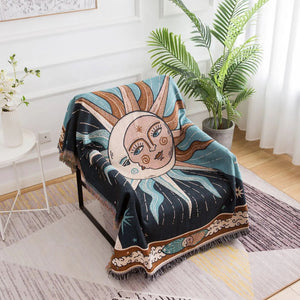 Tapisserie plaid soleil et lune drapée sur un fauteuil en salon bohème