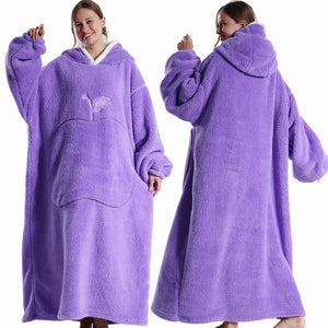 Un sweat plaid long à capuche ultra moelleux porté par une femme, avec une coupe ample et une grande poche frontale, offrant une allure enveloppante et confortable.
