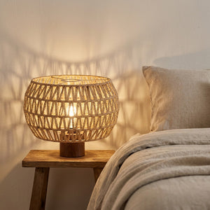 Abat-jour en corde de papier sur une lampe de chevet allumée dans une chambre