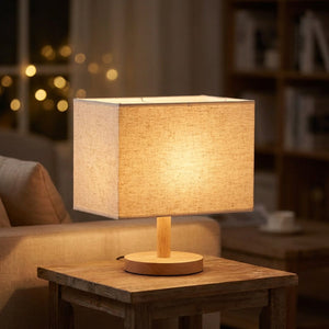 Abat-jour rectangulaire en lin beige posé sur une lampe de table dans un salon chaleureux
