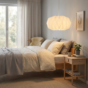 Abat-jour origami blanc dans une chambre cosy nordique