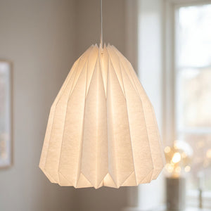 Abat-jour origami en papier blanc forme cloche allongee suspendu dans un interieur scandinave lumineux