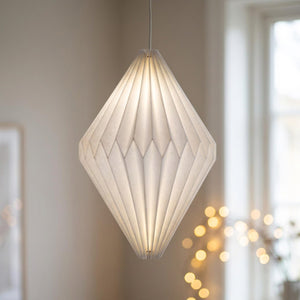 Abat-jour origami en papier blanc forme diamant allongee suspendu pres d une fenetre claire