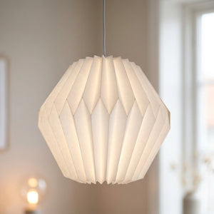 Abat-jour origami en papier blanc forme globe arrondi suspendu dans une piece cosy