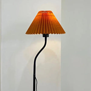 Abat-jour plissé orange de style japonais installé sur un lampadaire allumé
