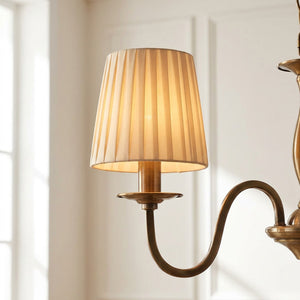 Abat-jour plissé en tissu beige sur lustre dans salon français