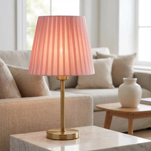 Abat-jour plissé rose sur lampe dorée dans un salon moderne